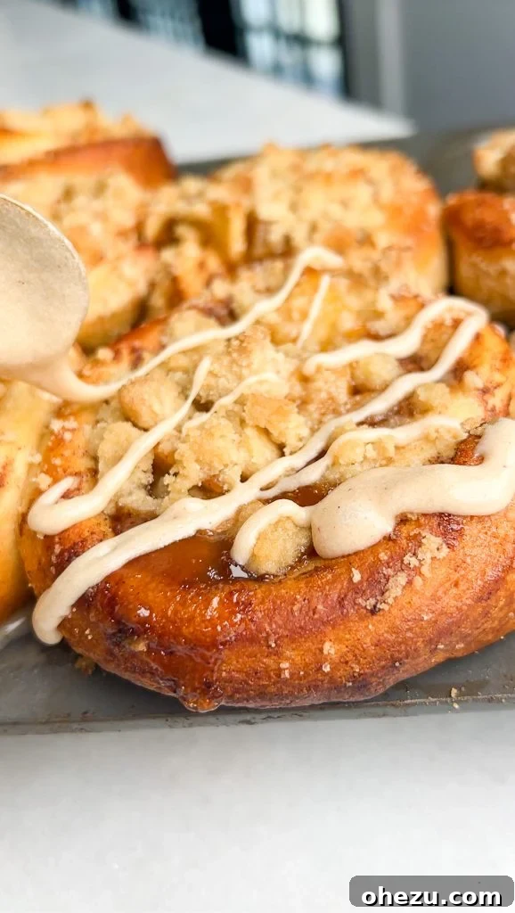 Delicious Apple Pie Cinnamon Rolls with creamy white icing drizzled over them
