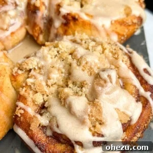 Top-down view of glazed Apple Pie Cinnamon Rolls on a white plate