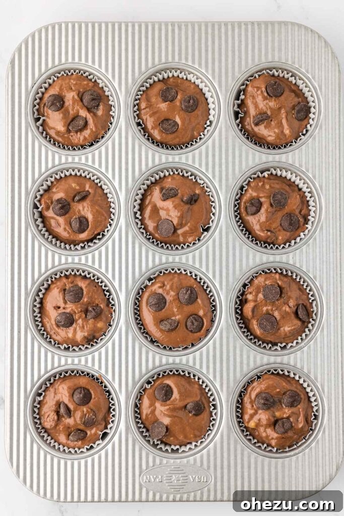 muffin batter in a muffin tin topped with chocolate chips