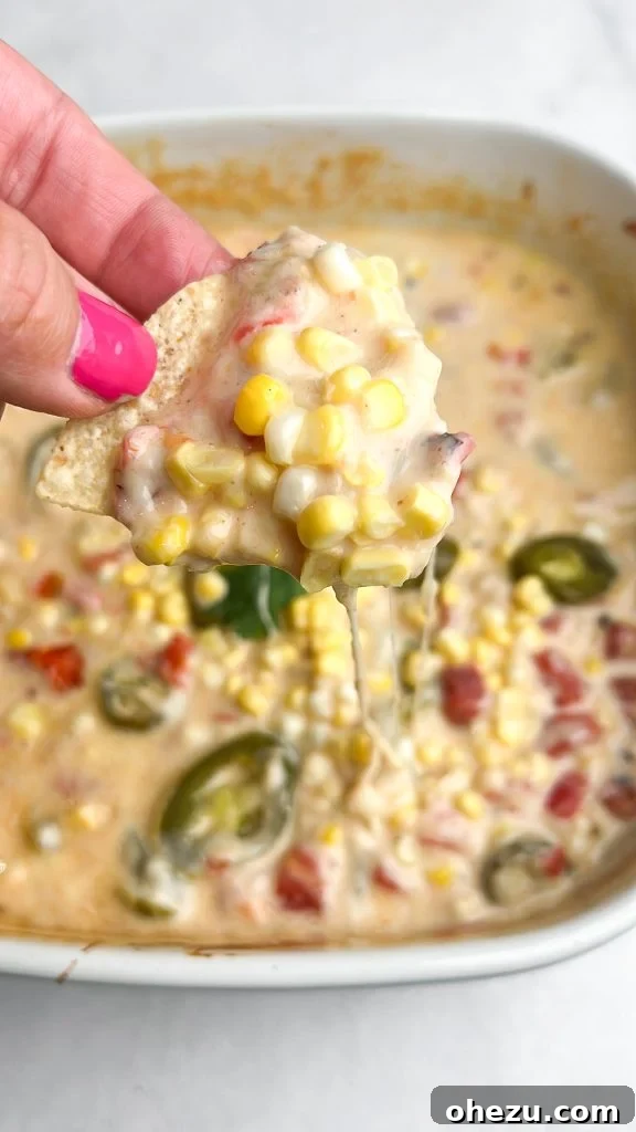 A bowl of creamy queso blanco with sweet corn and fresh cilantro, ready to be served with tortilla chips