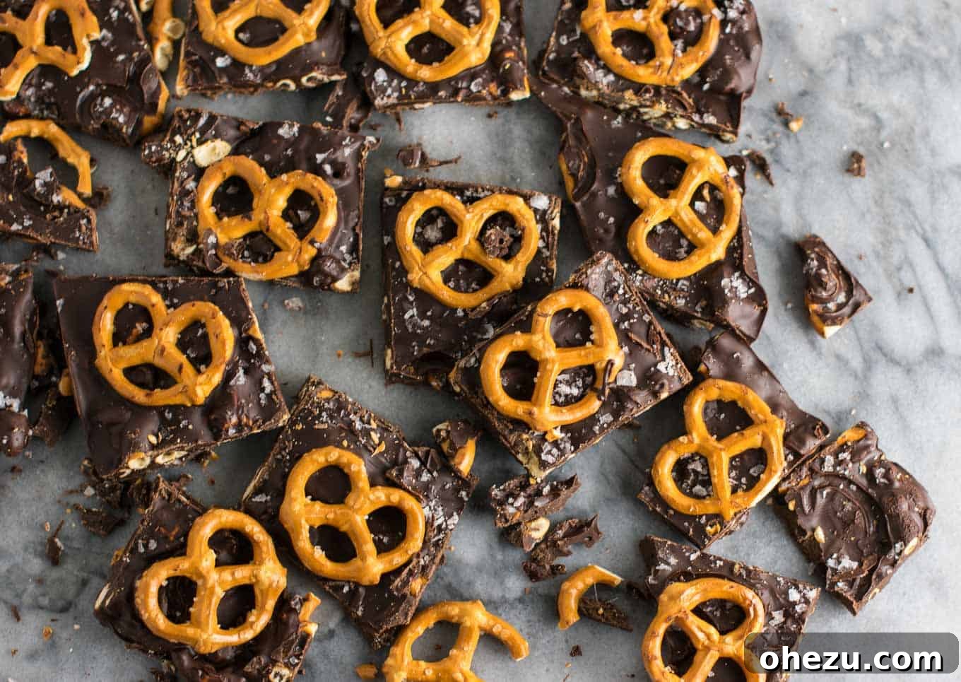Vegan Sweet & Salty Chocolate Pretzel Bark 4 Pieces of Vegan Chocolate Sea Salt Pretzel Bark arranged on a plate, showcasing the varying sizes and delightful textures.