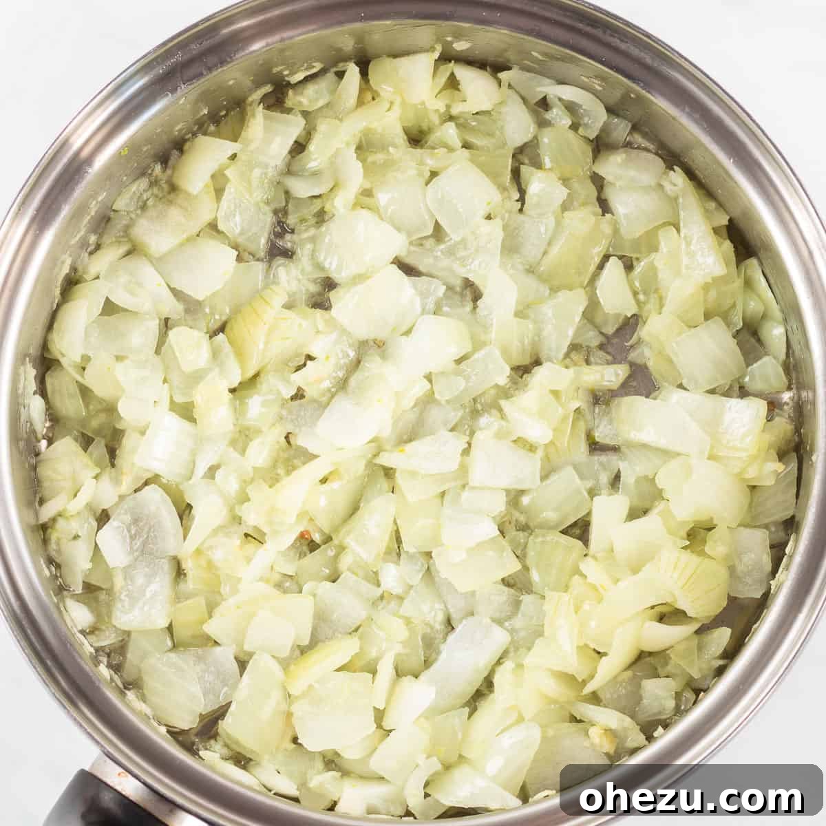 Sautéed translucent onions and golden minced garlic in a non-stick pan, perfectly cooked for the pot pie filling.