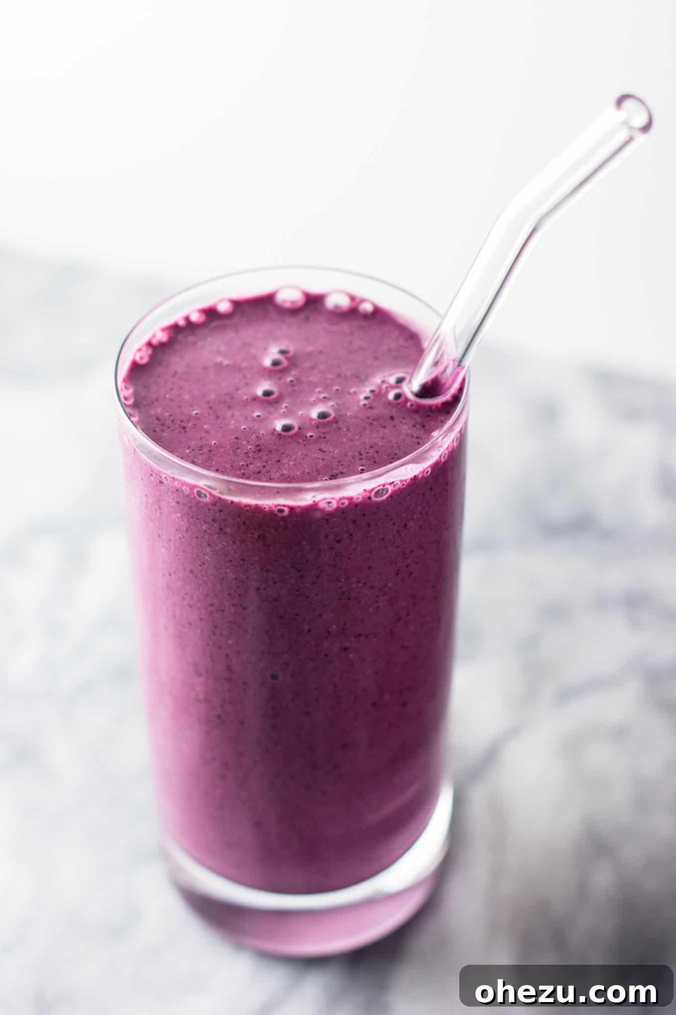 A final image of the blueberry pie smoothie in a glass, ready to be enjoyed. The visual emphasizes the freshness and appeal of this homemade healthy drink. #healthy #blueberrysmoothie #blueberrypiesmoothie #vegetarian #greekyogurt #lemonzest #glutenfree