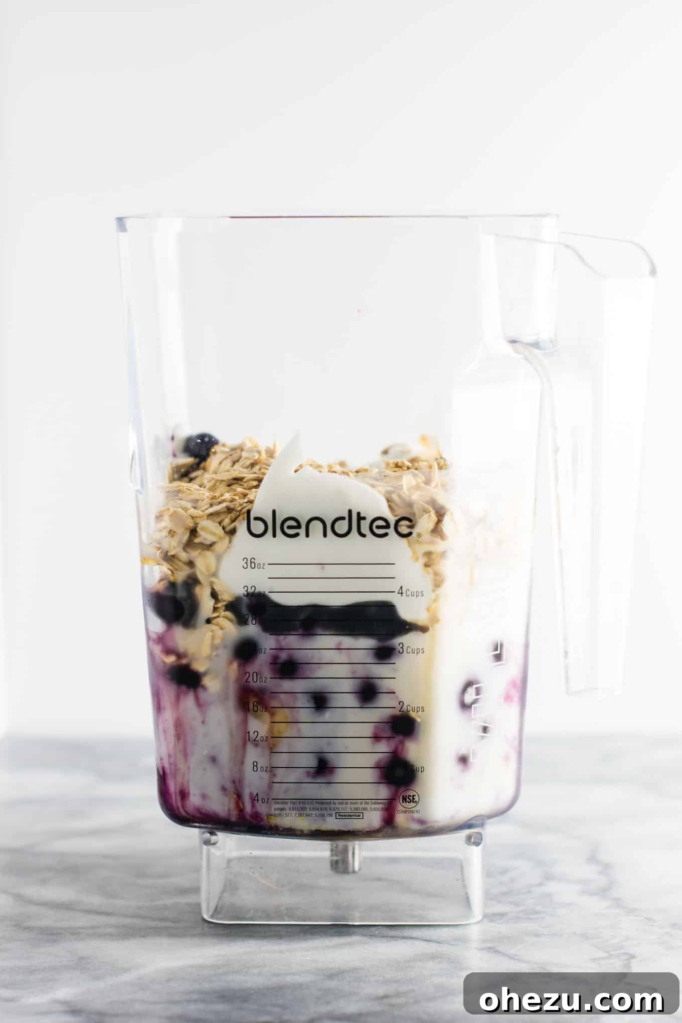 Another perspective of the healthy blueberry pie smoothie in a tall glass, showcasing its vibrant color and smooth consistency. Prepared with wholesome ingredients for a nutritious breakfast or dessert. #healthy #blueberrysmoothie #blueberrypiesmoothie #vegetarian #greekyogurt #lemonzest #glutenfree