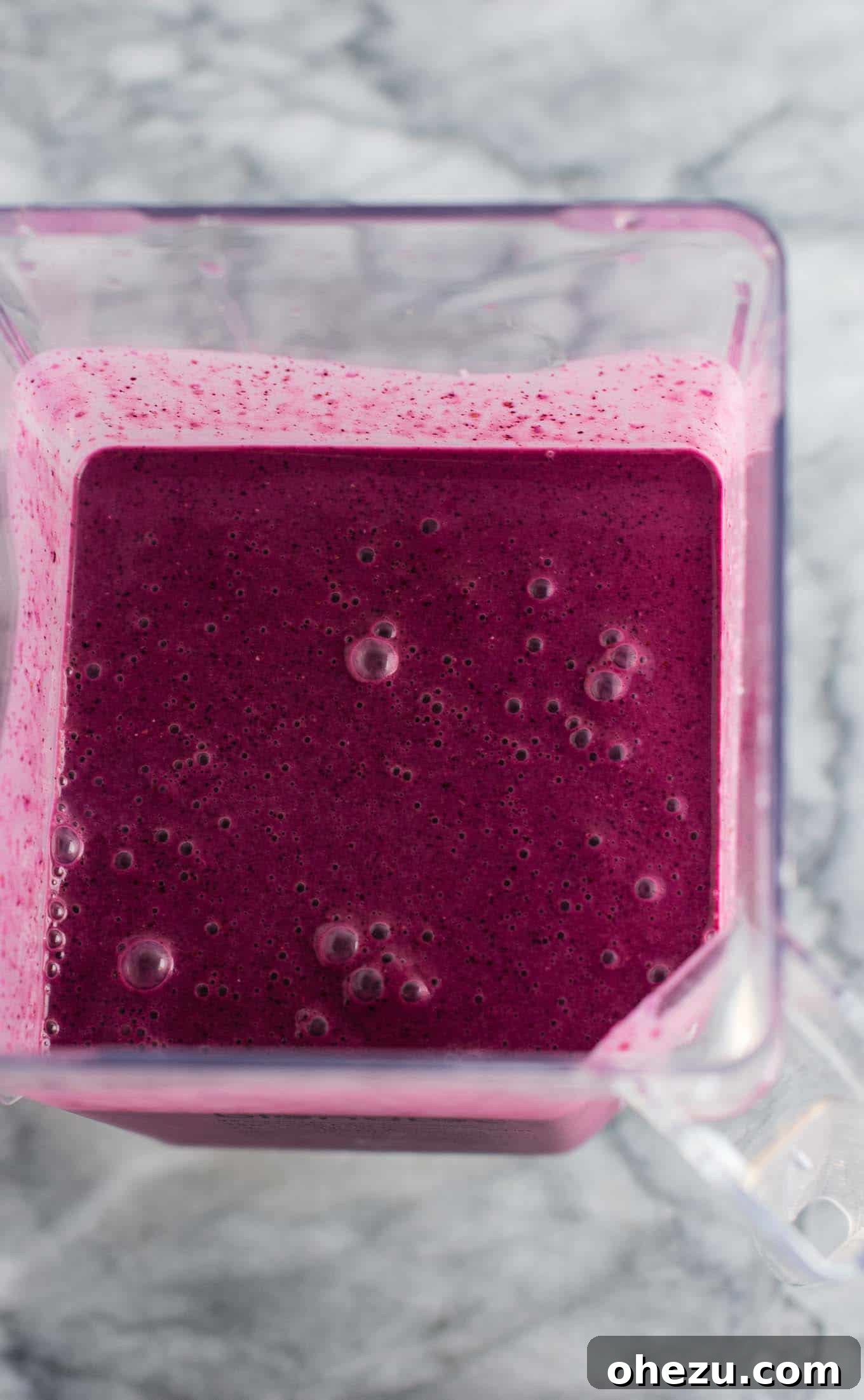 A refreshing blueberry pie smoothie, presented beautifully in a glass against a light background. Its rich, deep purple color is truly eye-catching and inviting. #healthy #blueberrysmoothie #blueberrypiesmoothie #vegetarian #greekyogurt #lemonzest #glutenfree