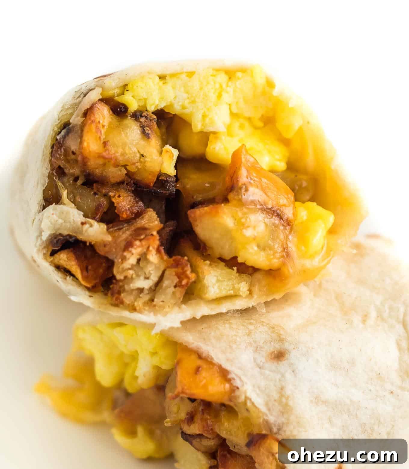 Breakfast Burrito Bliss 3 A breakfast burrito generously stuffed with golden scrambled eggs and a vibrant crispy potato hash, ready to be enjoyed.