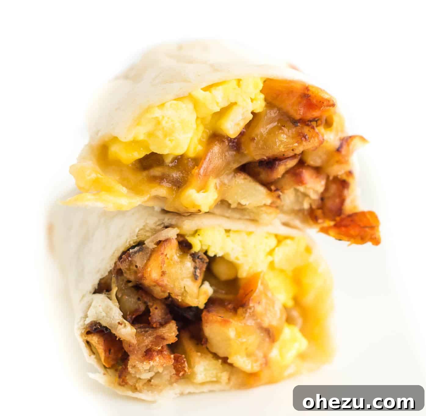 Breakfast Burrito Bliss 4 Two breakfast burritos, expertly cut in half and stacked, showcasing their delicious fillings and golden-brown tortillas.