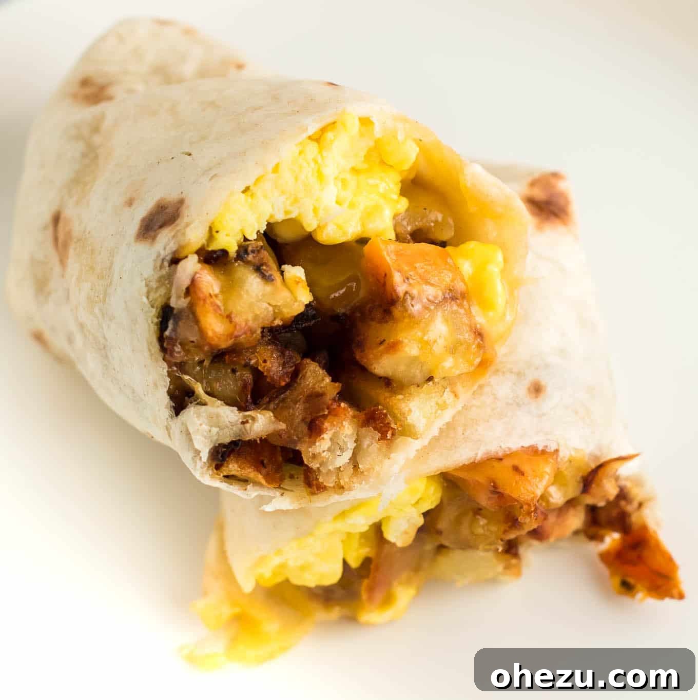 Breakfast Burrito Bliss 5 A perfectly wrapped breakfast burrito, sliced in half to display its tempting contents, ideal for a morning meal.