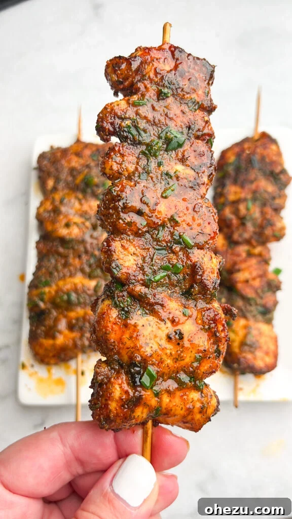 Close-up of golden brown Buffalo Ranch Chicken Skewers garnished with fresh chives