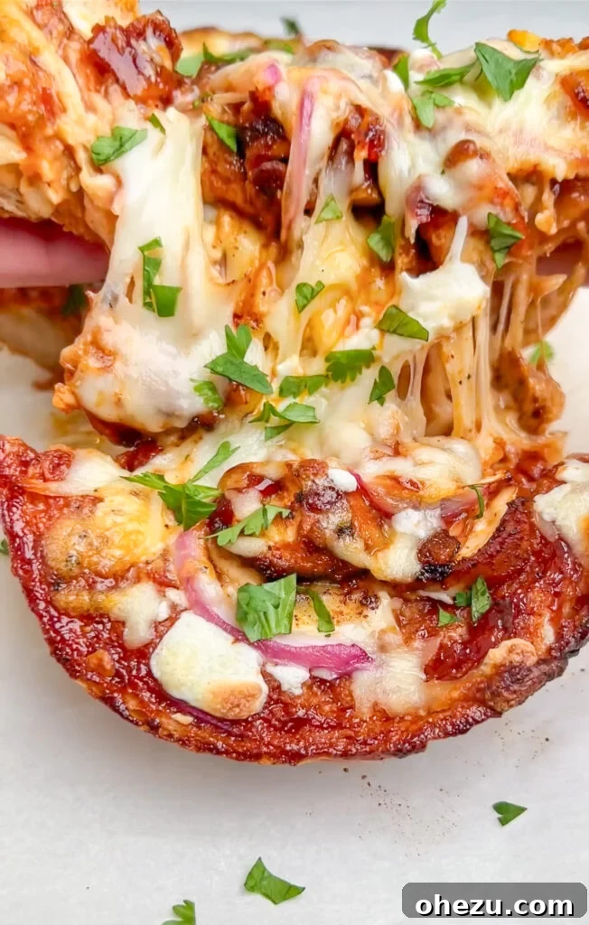 Signature BBQ Chicken French Bread Pizza 2 Delicious BBQ Chicken French Bread Pizza on a cutting board, garnished with fresh cilantro, ready to be served.