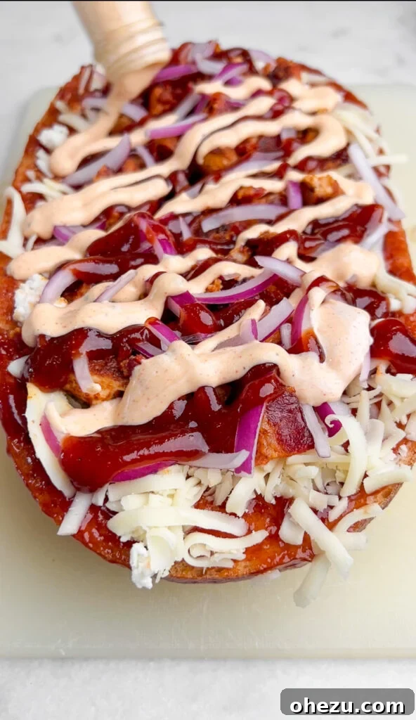 Signature BBQ Chicken French Bread Pizza 4 Close-up shot of French bread pizza ingredients, including chicken, bacon, cheese, red onion, and sauces.
