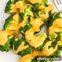 Creamy cheese sauce drizzled over steamed broccoli, highlighting the perfect pairing.