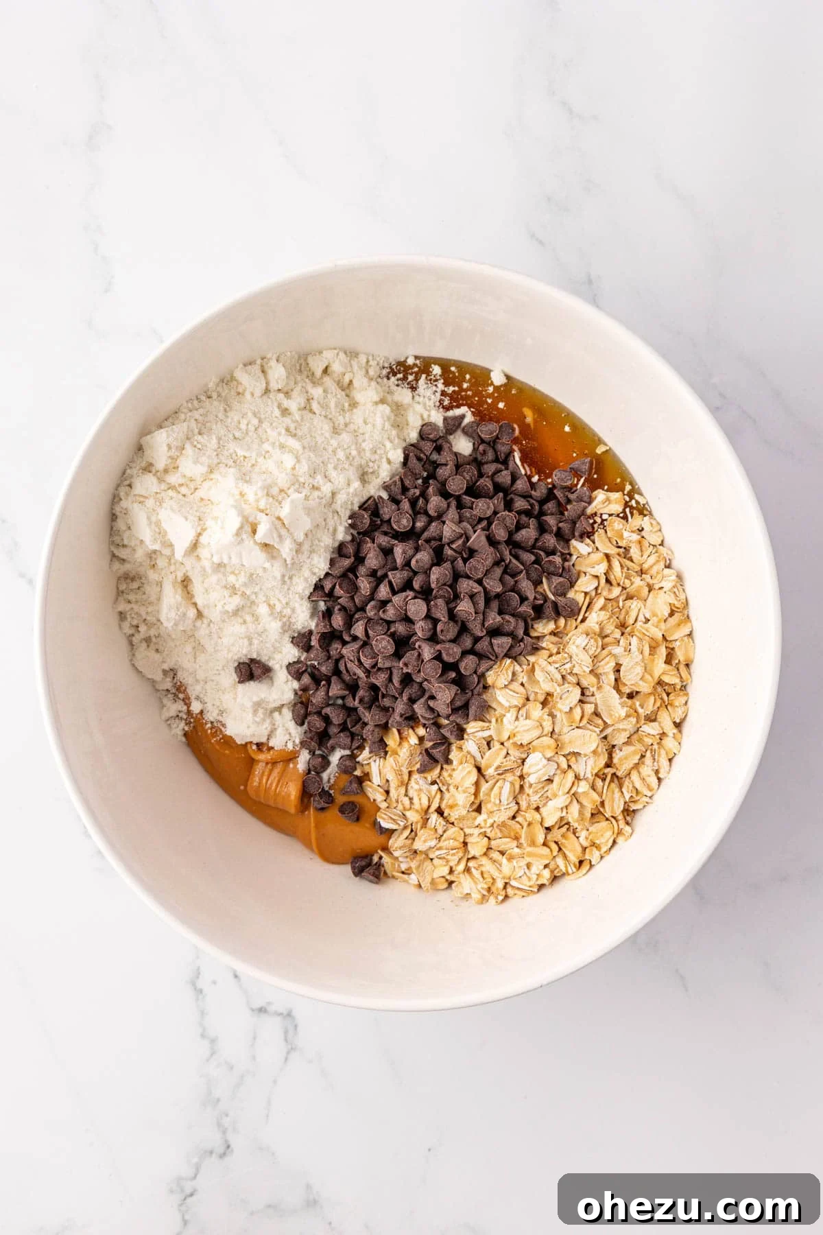 All protein bar ingredients in a mixing bowl before stirring