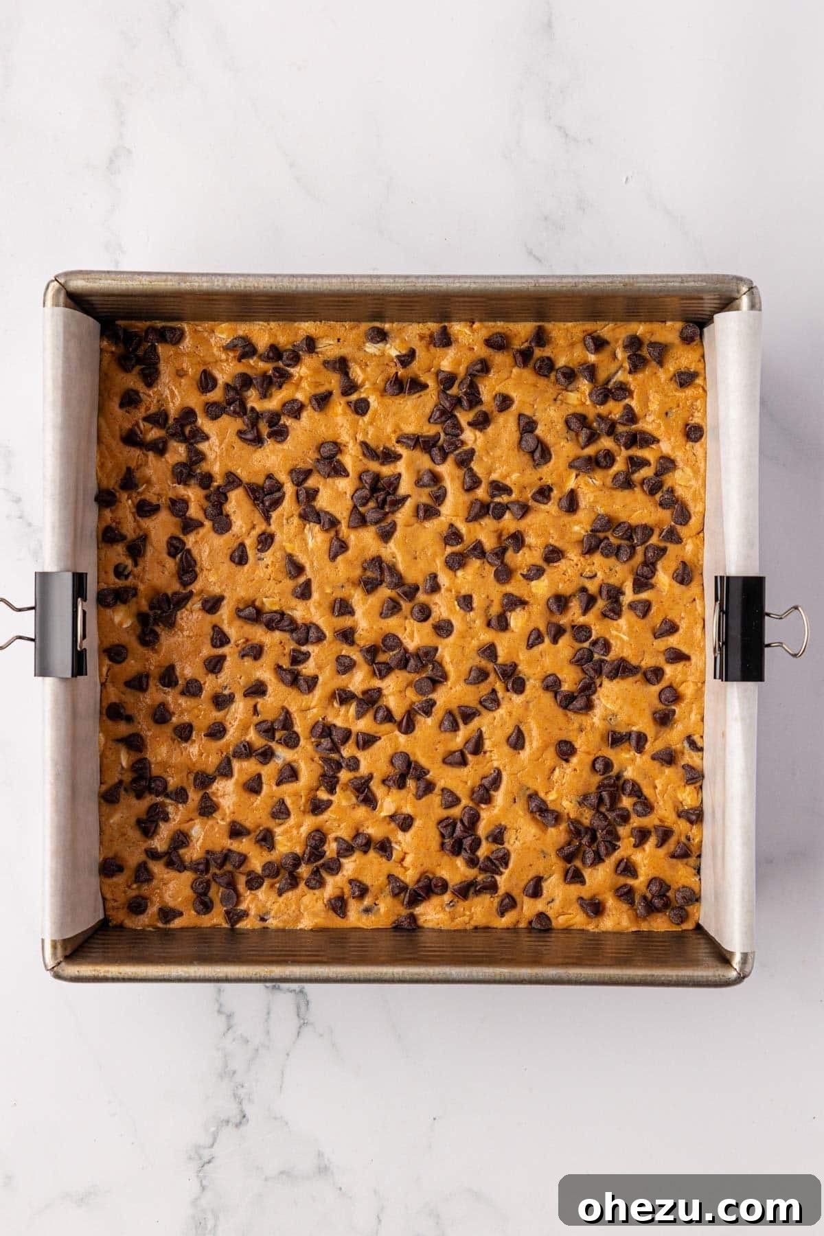 Protein bar batter topped generously with mini chocolate chips