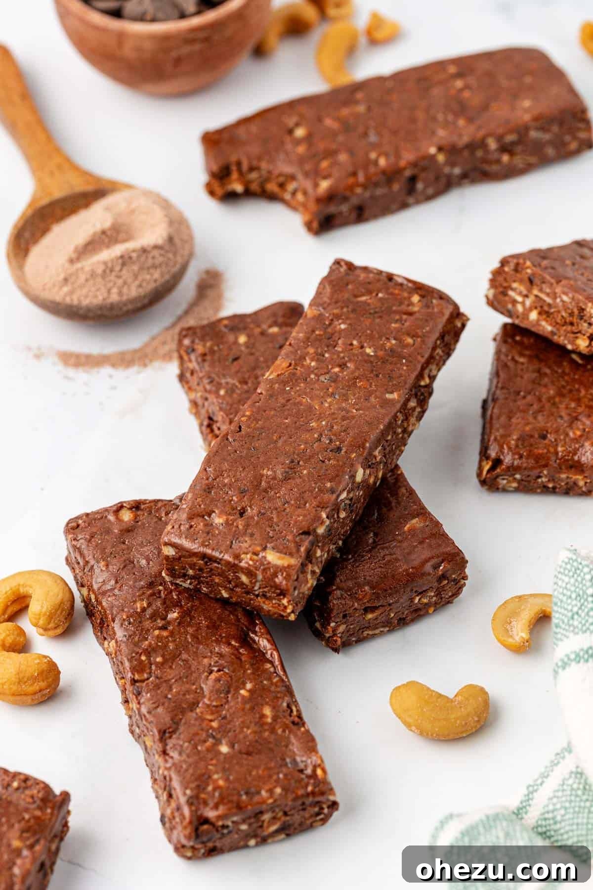 A person holding a delicious chocolate cashew protein bar, showcasing its texture