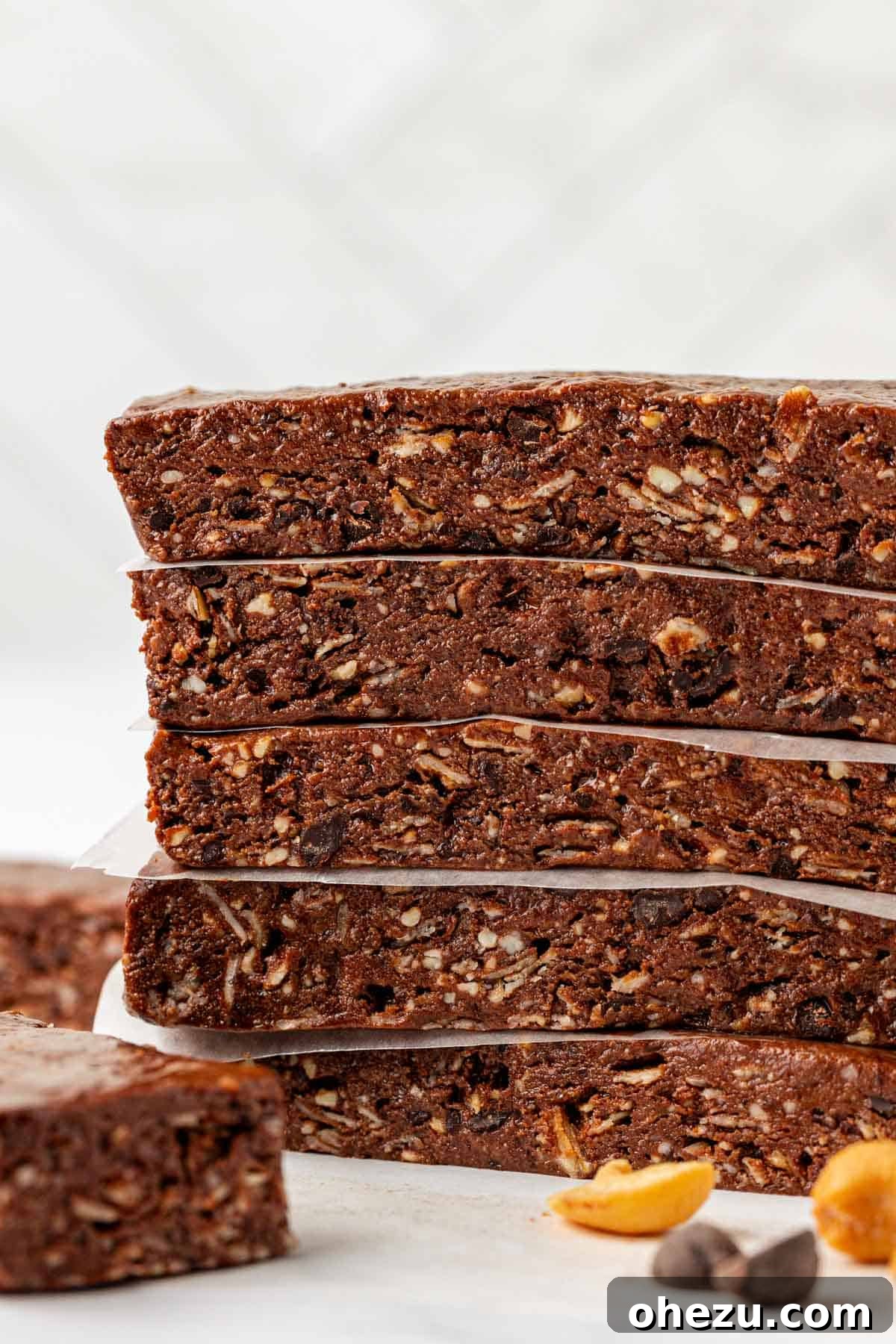 Two dark chocolate cashew protein bars stacked, showing their dense texture