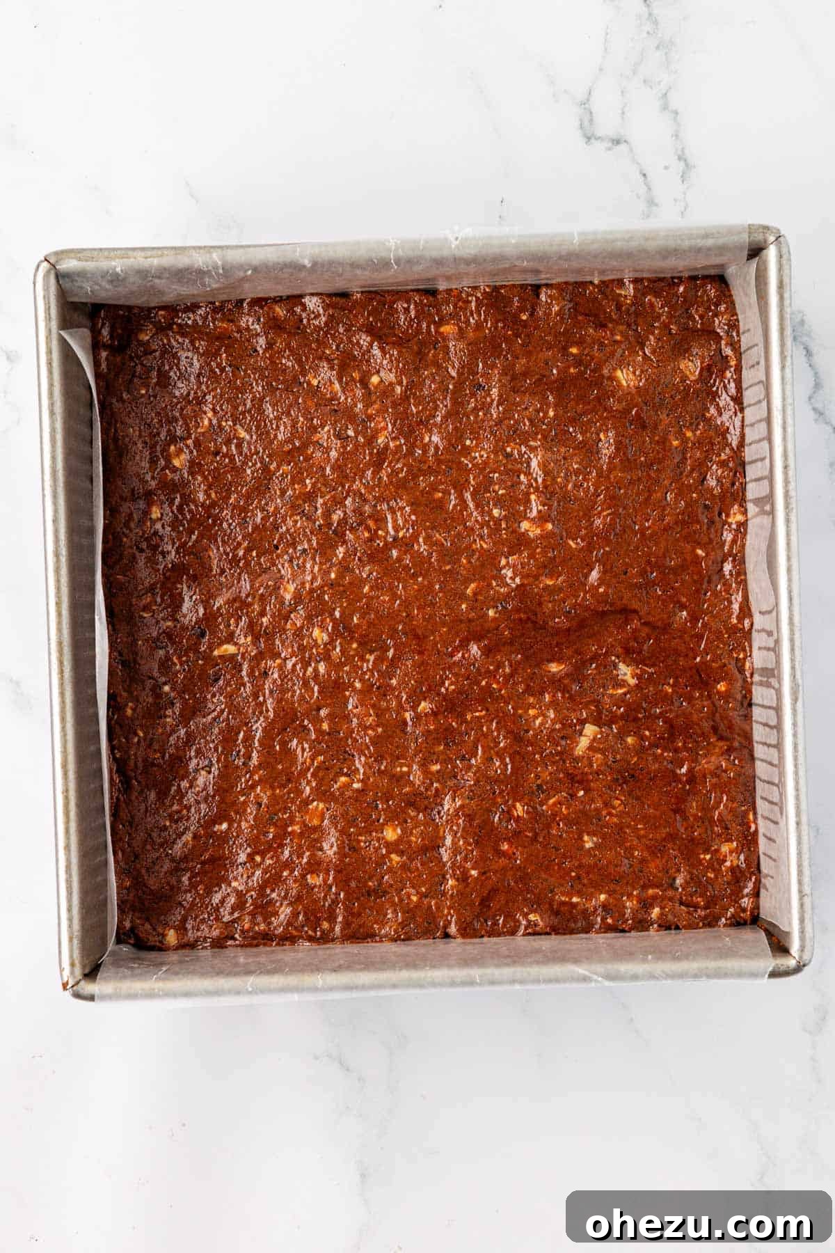 Protein bar batter firmly pressed into an 8x8 inch dish lined with wax paper