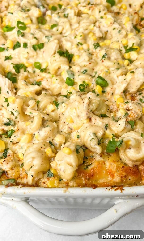 Close-up of baked Elote Mac and Cheese with a spoon taking a serving