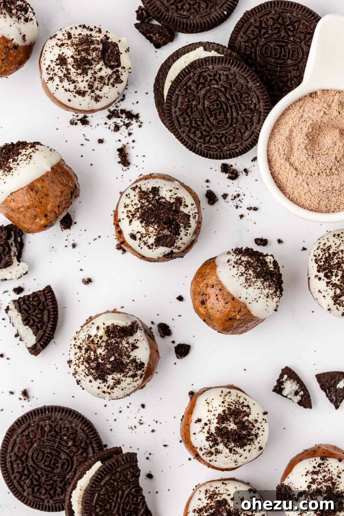 Two hands holding a fresh batch of cookies and cream protein balls, showing their delicious texture.