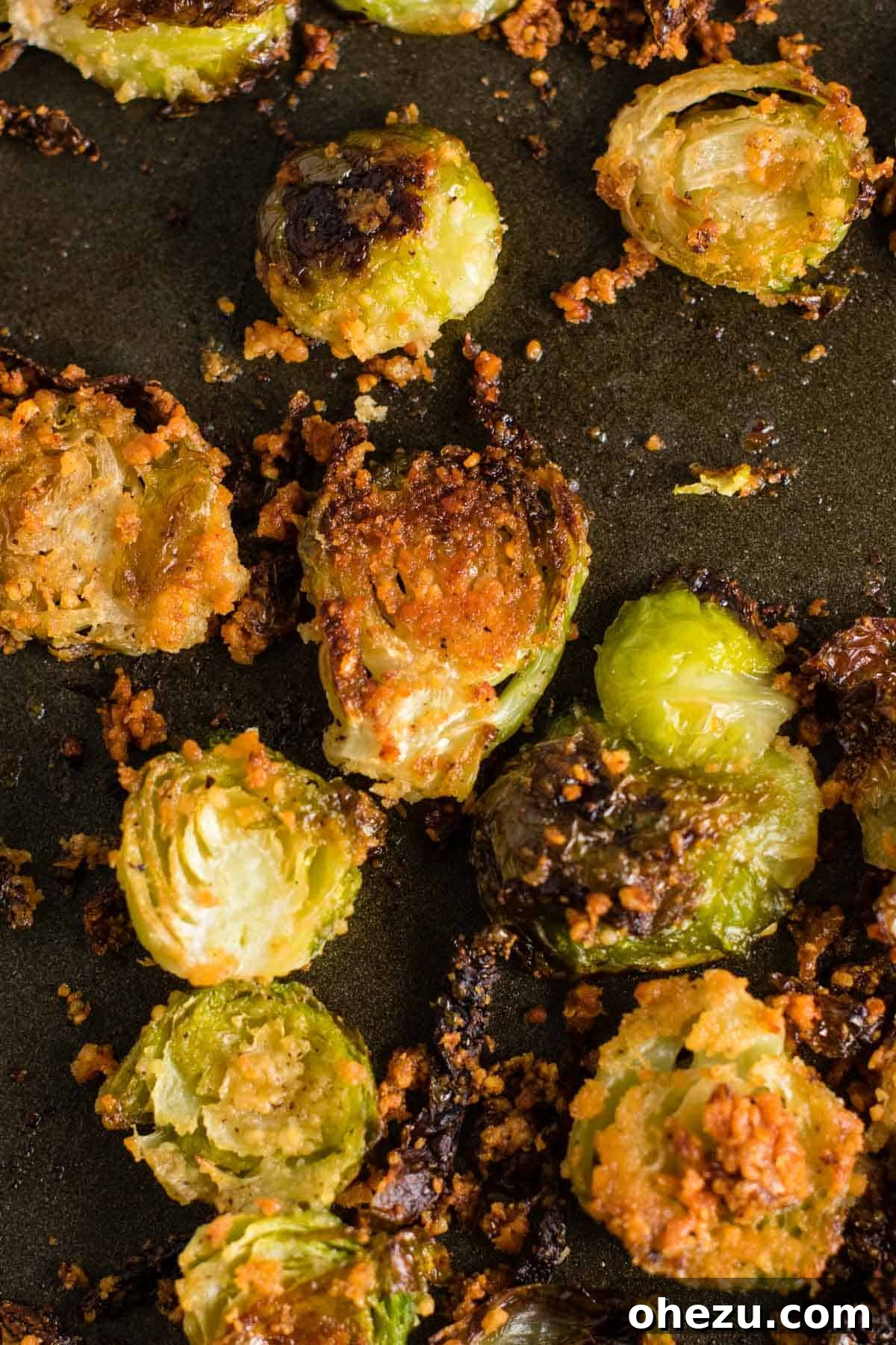 Savory Sprout Crisps 2 brussel sprout chips on a baking sheet, golden brown and crispy