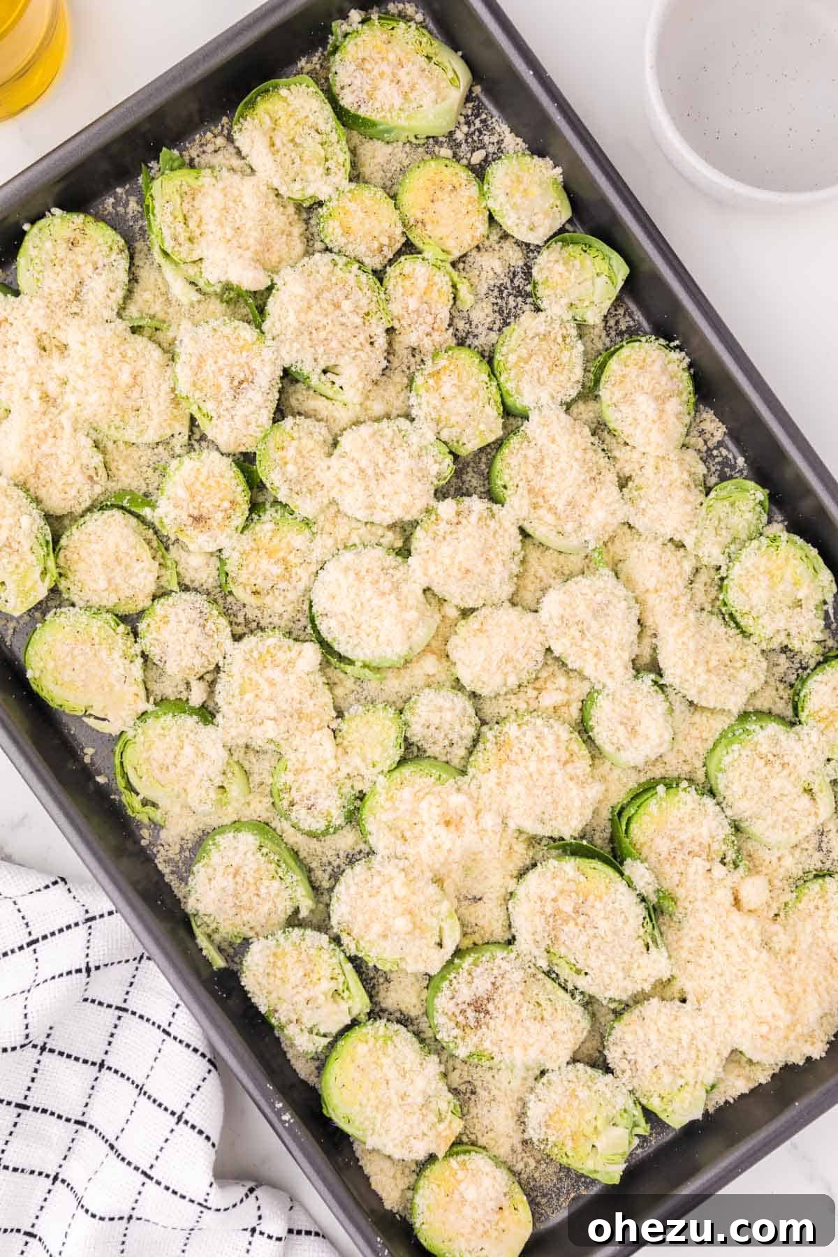 Savory Sprout Crisps 7 adding parmesan and spices to the brussels sprouts on a baking sheet