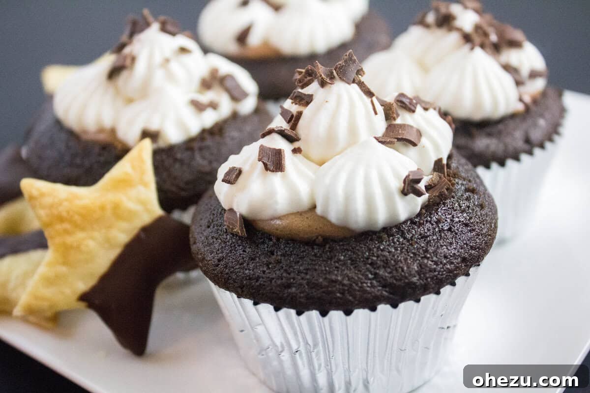 Whiskey Chocolate French Silk Pie Cupcakes 4 A stunning spread of Whiskey Chocolate French Silk Pie Cupcakes, each adorned with whipped cream, chocolate shavings, and a chocolate-dipped pie crust cutout