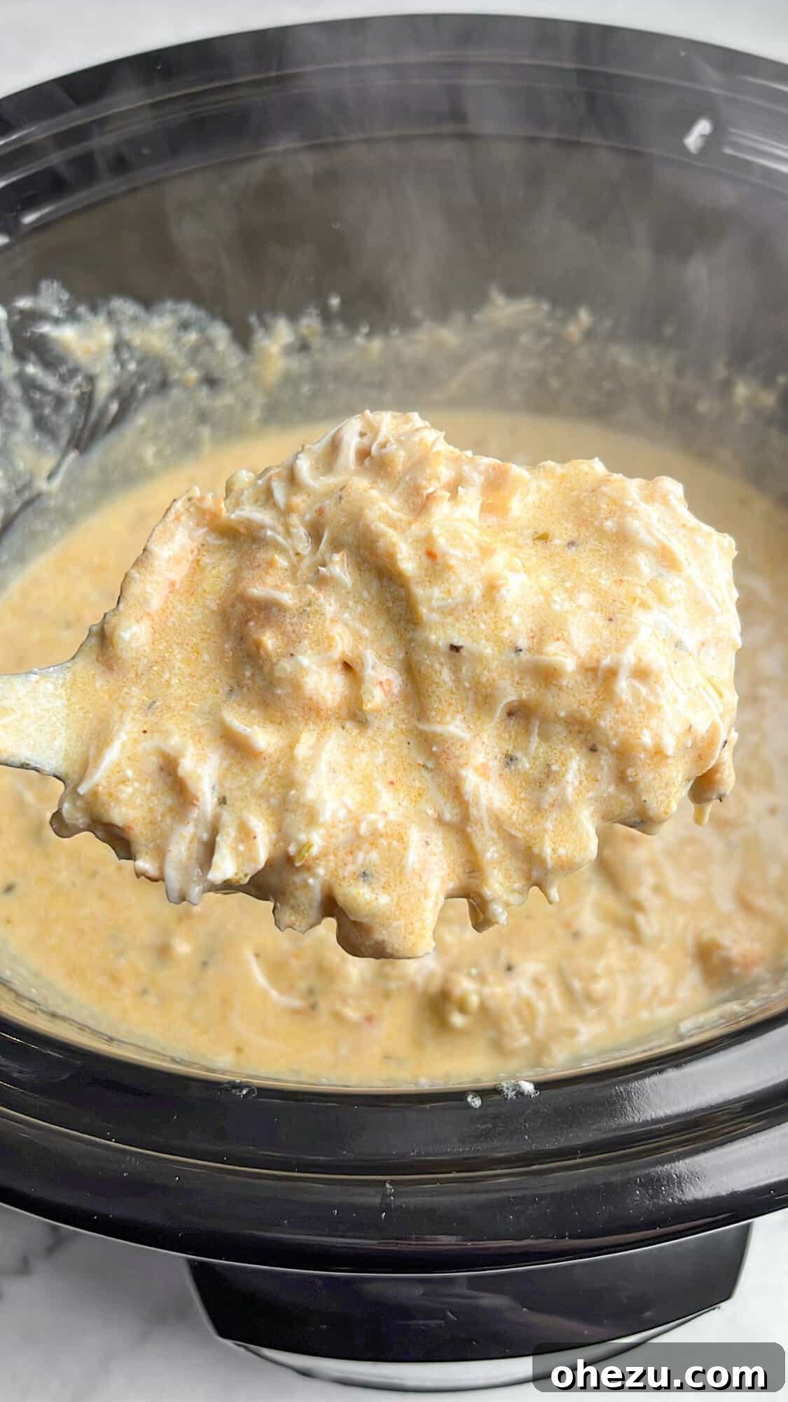 Viral Slow Cooker Chicken Pasta with Olive Garden Dressing 7 A dish of Olive Garden Chicken Pasta with a fork, ready to be eaten