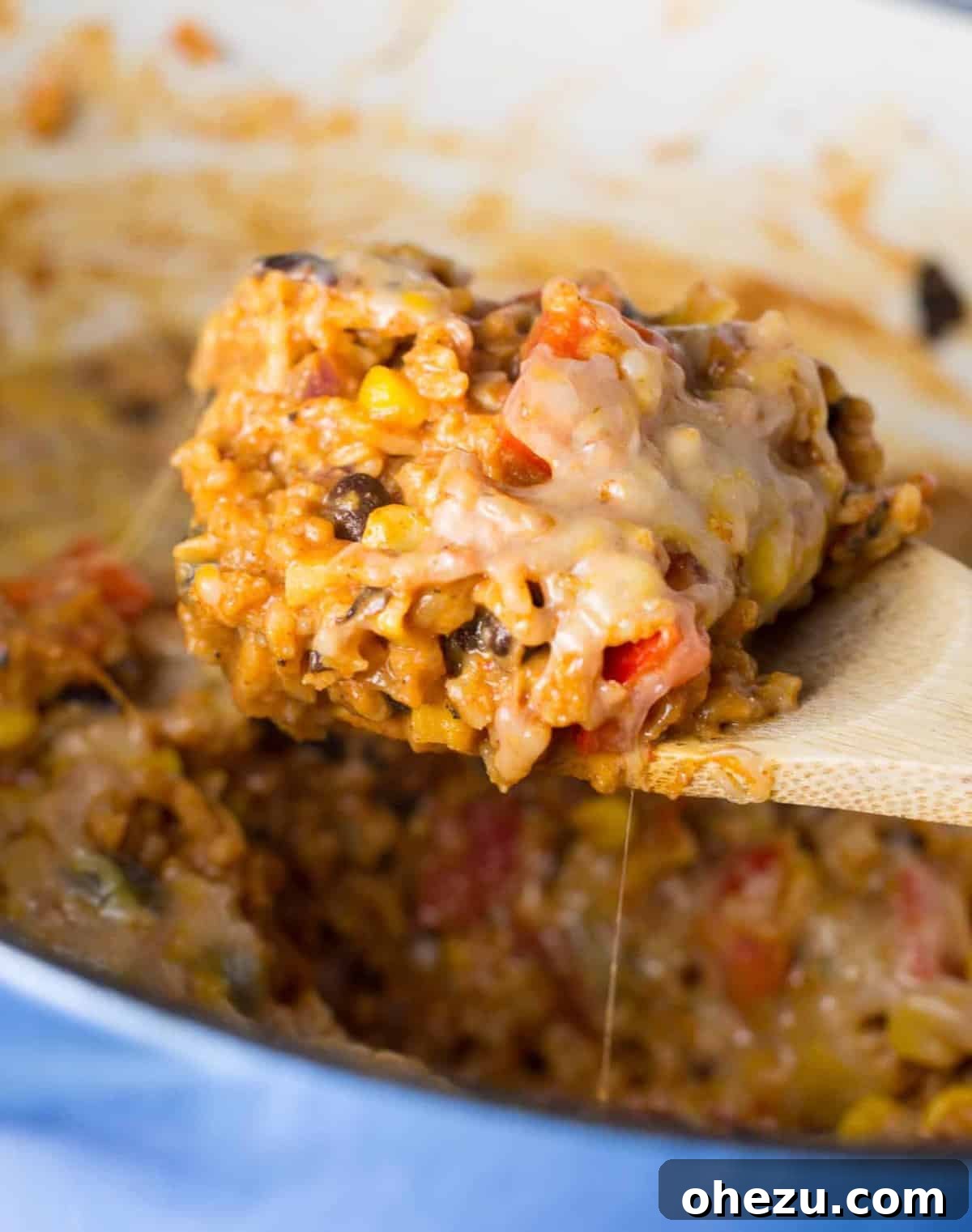 A bubbling Vegetarian Mexican Rice Casserole, topped with melted cheese and fresh green onions, served in a white baking dish.