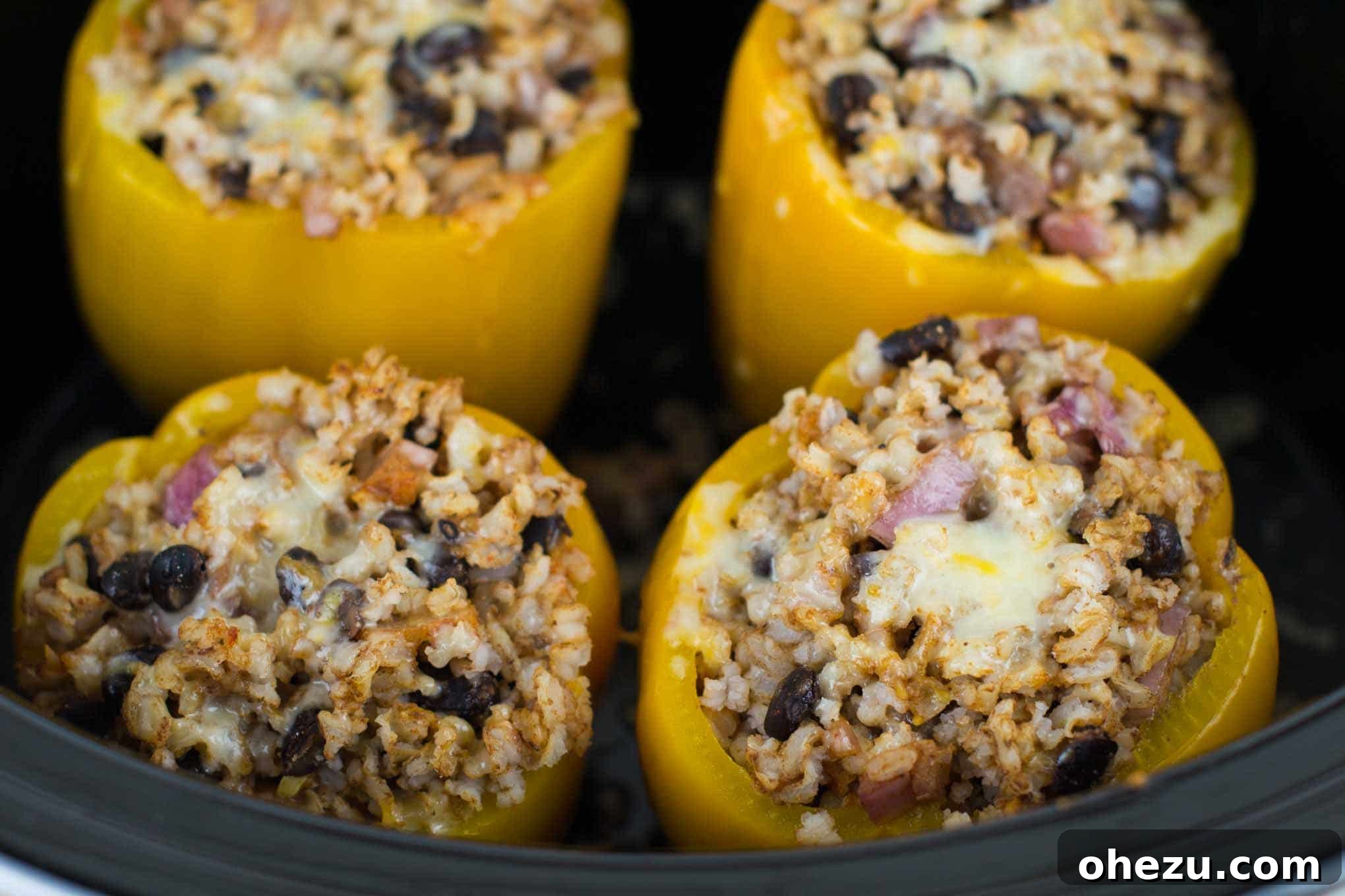 Colorful bell peppers, stuffed with a hearty vegetarian filling, simmering gently in a crockpot.