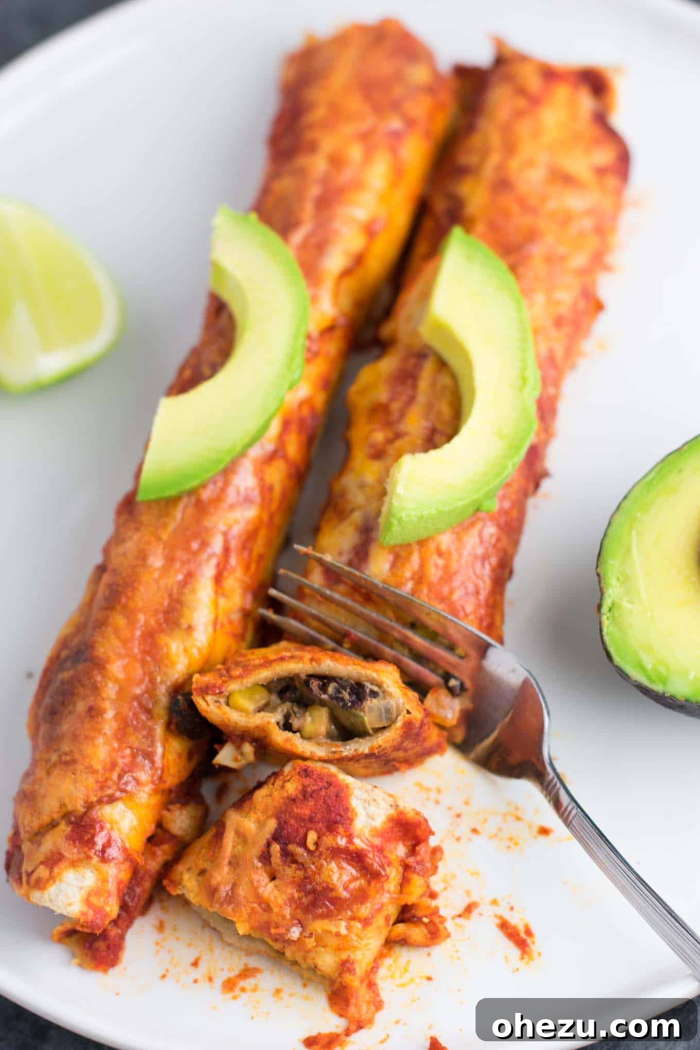 A baking dish filled with bubbling, cheesy vegetarian enchiladas, topped with fresh cilantro, ready to be served.
