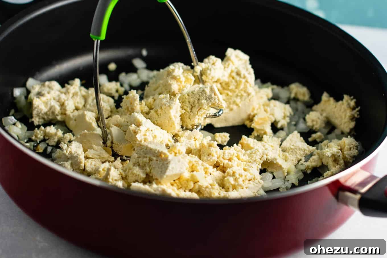 Tofu mashed to an egg-like consistency in a skillet for a delicious #eggfree #veganbreakfast.