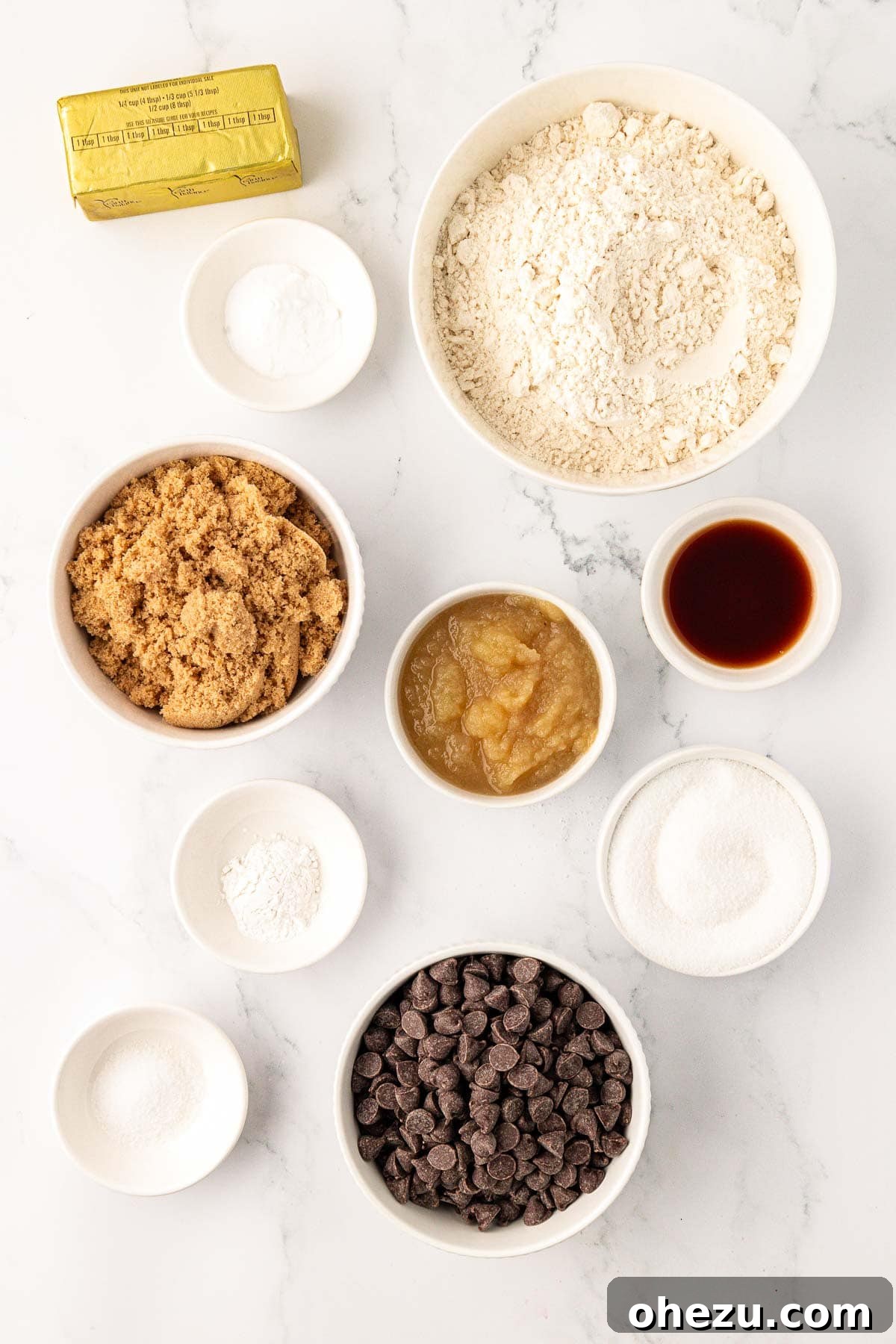 Heavenly Vegan Chocolate Chip Cookies 4 A flat lay photograph of all the dry and wet ingredients needed to make vegan chocolate chip cookies, neatly arranged on a white surface.