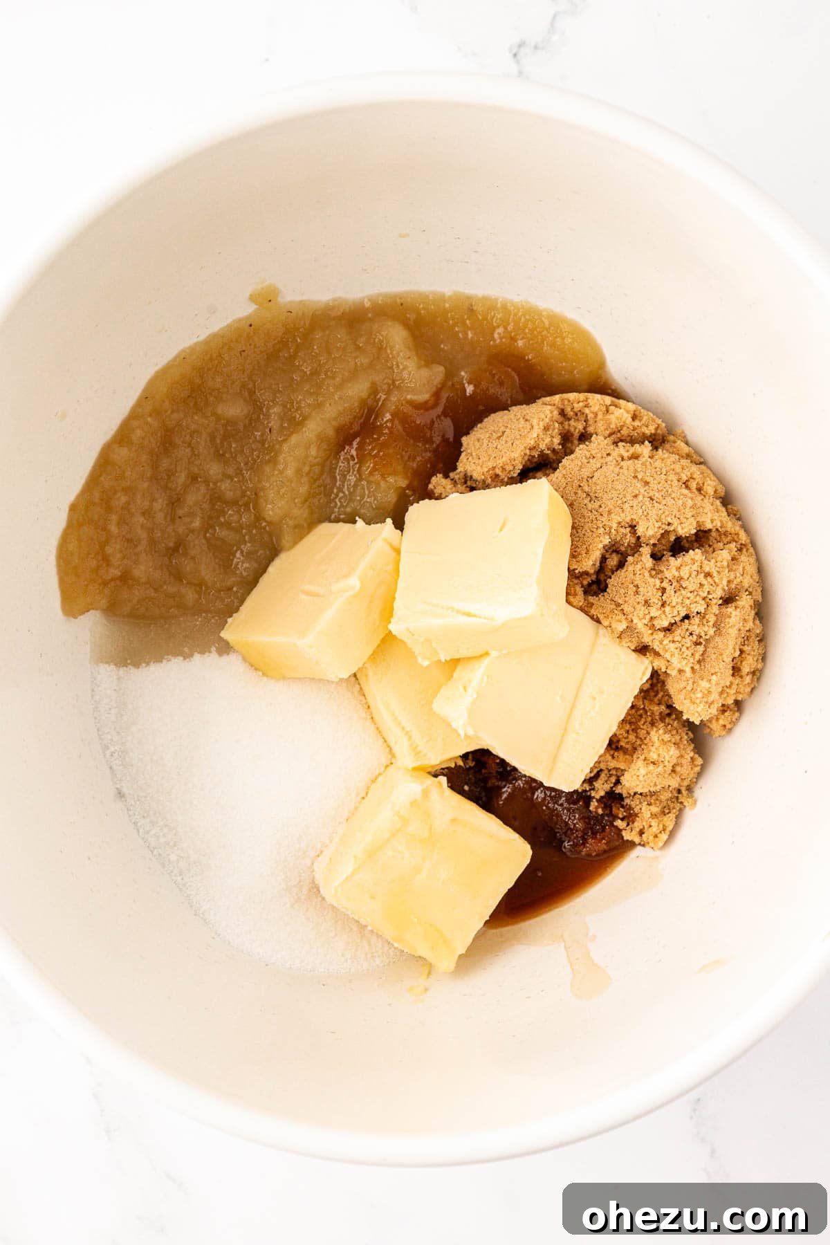 Heavenly Vegan Chocolate Chip Cookies 7 Wet ingredients including sugars, applesauce, vegan butter, and vanilla extract in a mixing bowl before combining.