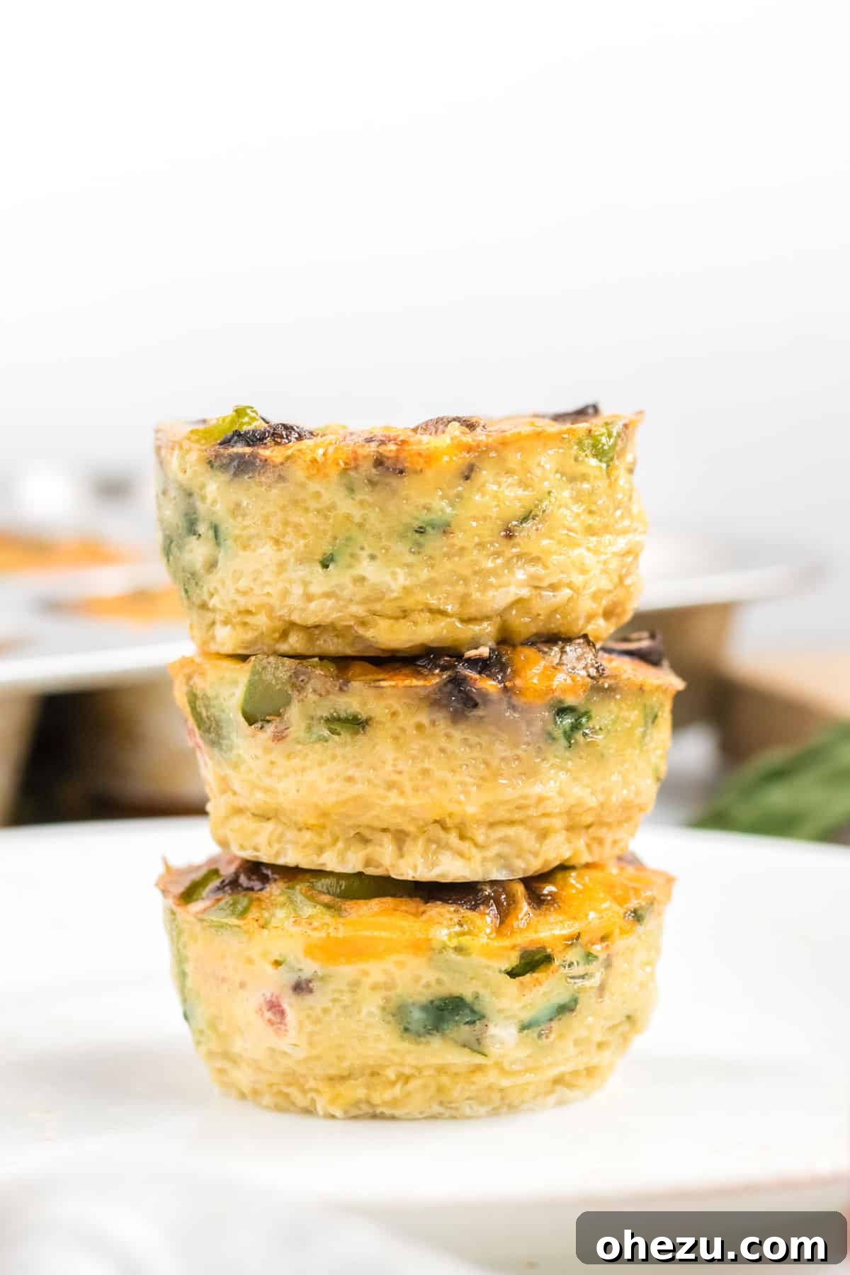 A final shot of stacked egg muffins, highlighting their perfect shape and golden appearance, inviting readers to try the recipe.
