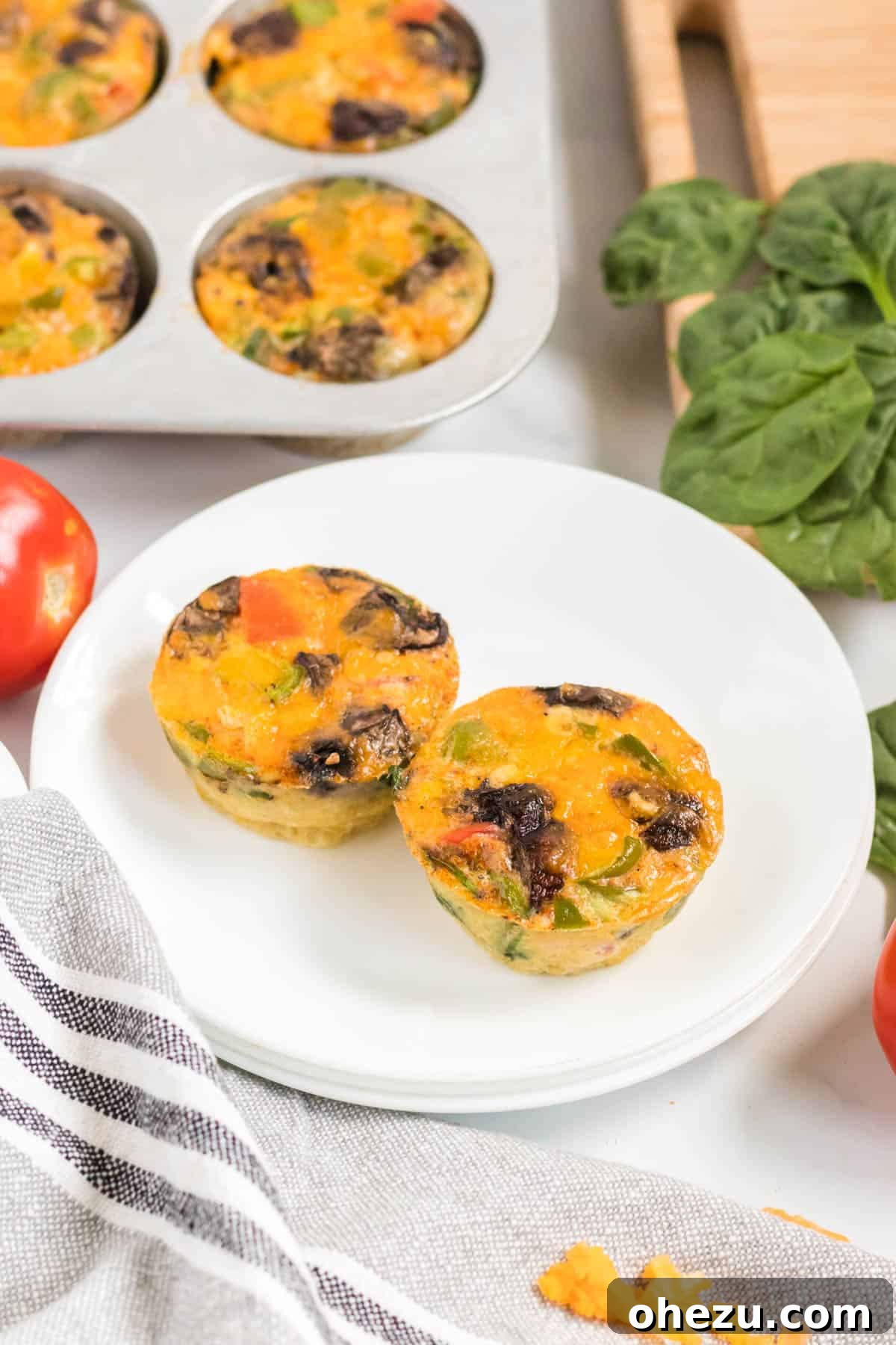 Two perfectly cooked egg muffins resting on a clean plate, ready for a quick and healthy meal.