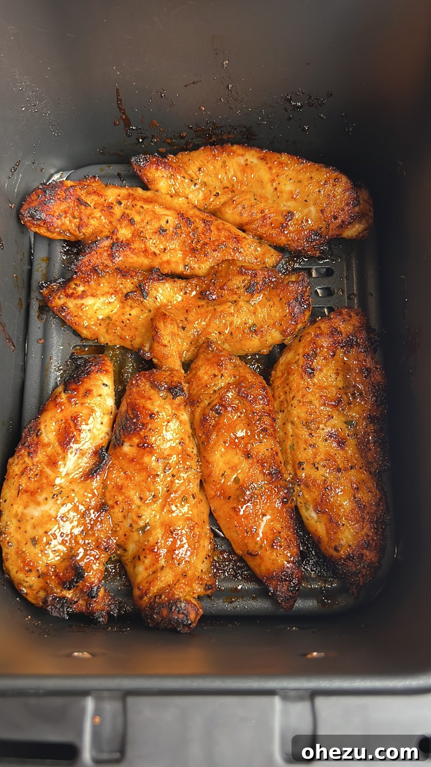 Air-Fried Hot Lemon Pepper Ranch Chicken Tenders 8 Four perfectly cooked and glazed air fried chicken tenders resting in the air fryer basket after cooking.