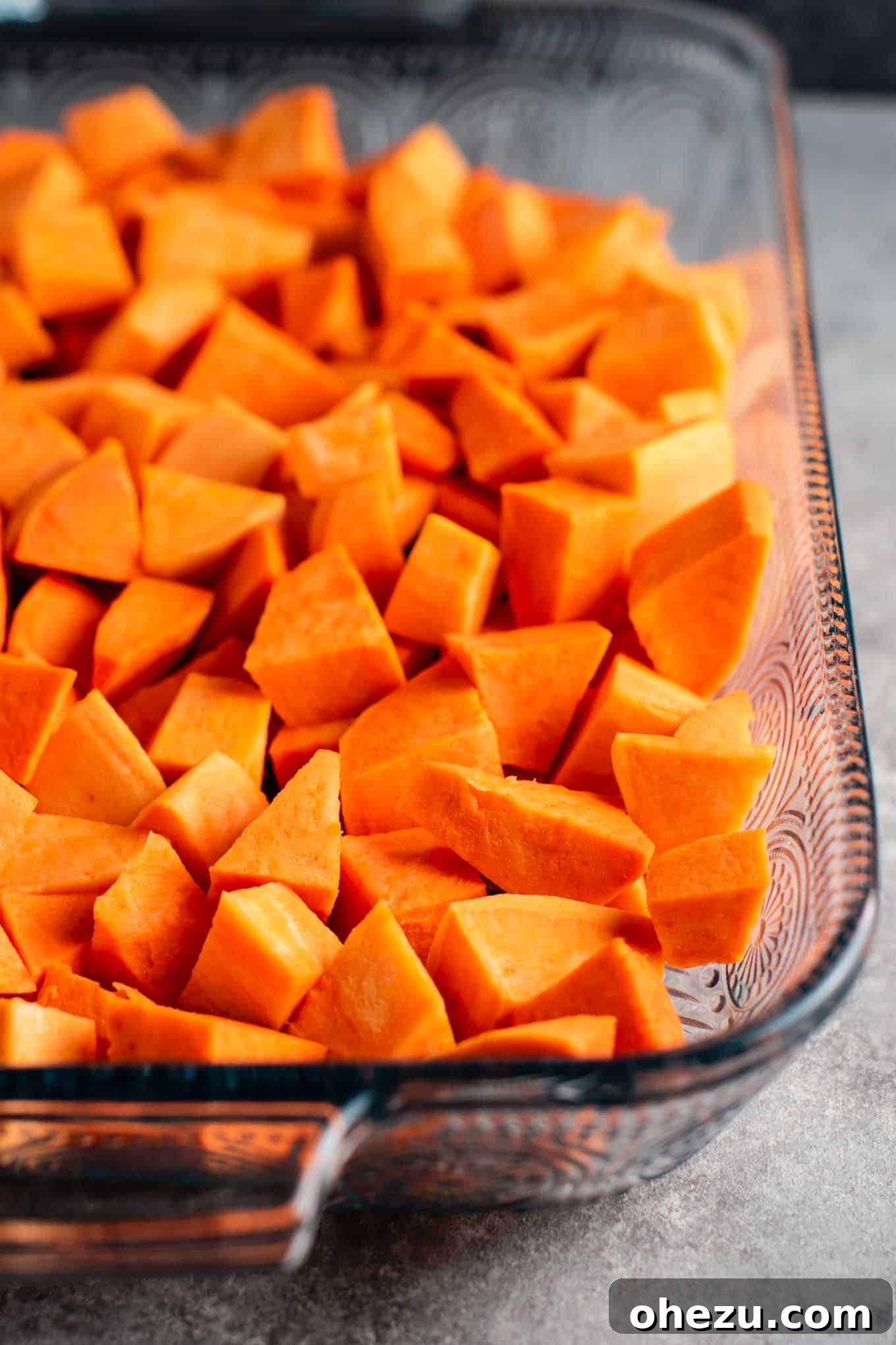 Diced and seasoned sweet potatoes in a casserole dish