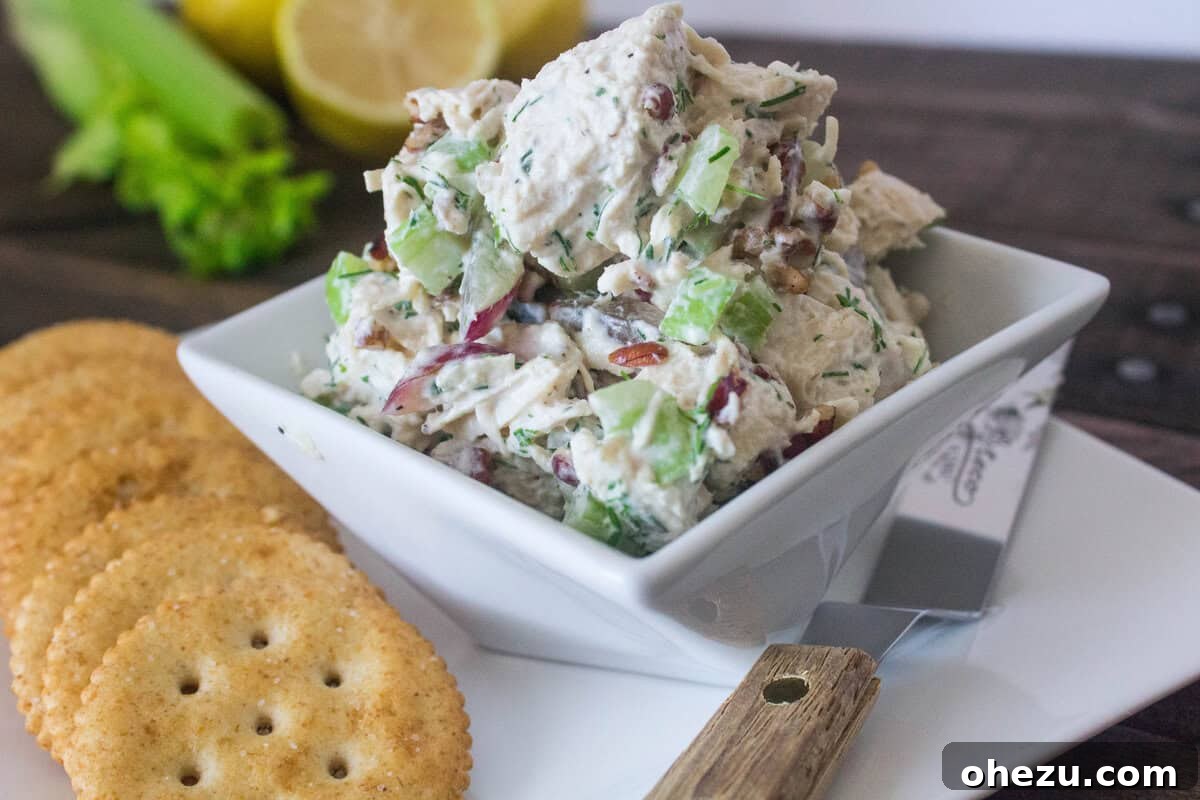 Wholesome and Satisfying Chunky Chicken Salad 2 A large bowl filled with freshly made Clean & Healthy Chunky Chicken Salad, showing cubed chicken, green dill, red grapes, and crisp celery, ready to be served.