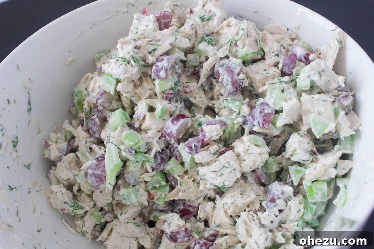 Wholesome and Satisfying Chunky Chicken Salad 5 Close-up view of the Clean & Healthy Chunky Chicken Salad, showcasing the diverse and appealing textures of tender cubed chicken, sweet grapes, crisp celery, and crunchy pecans, all beautifully mixed in the creamy dill dressing.