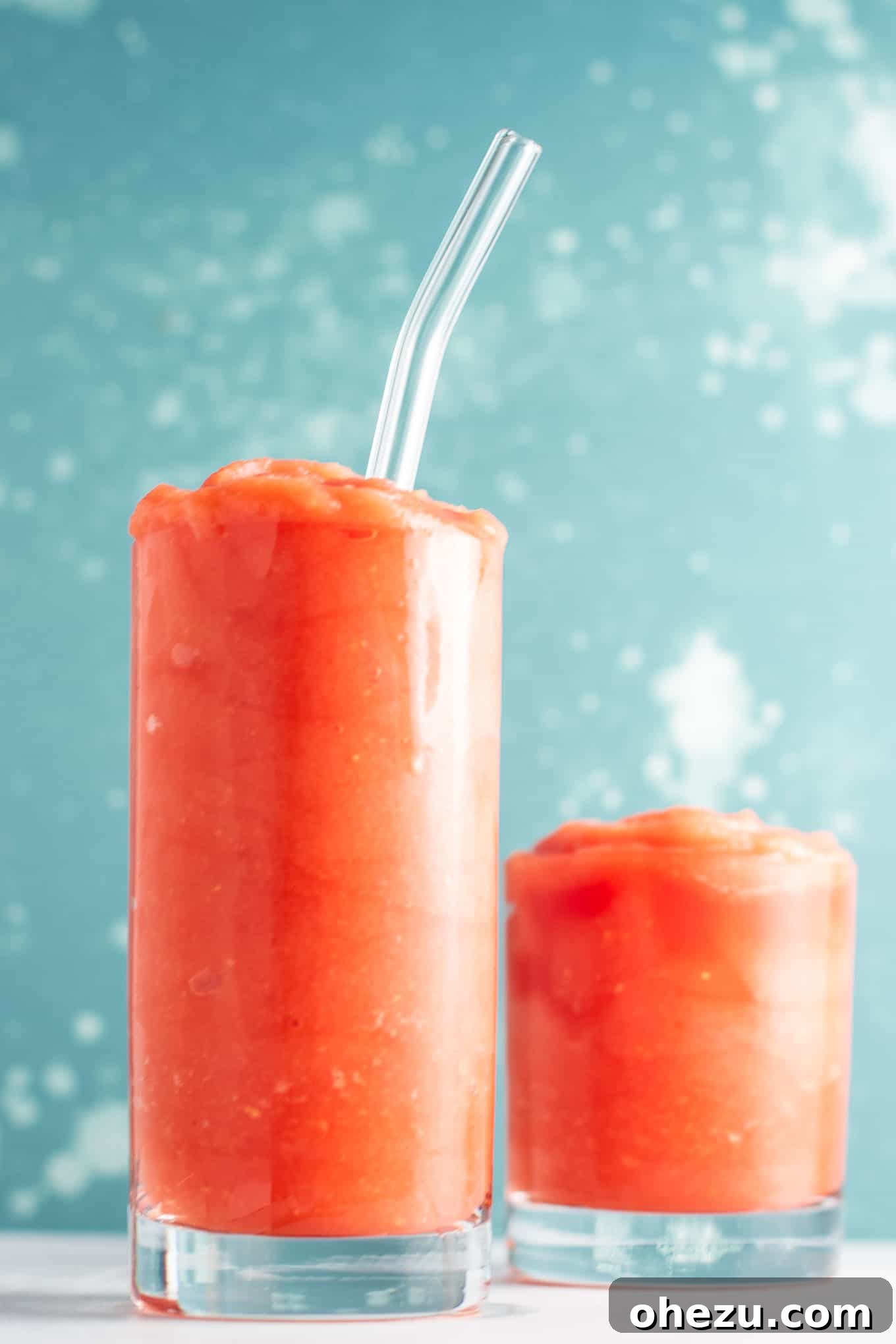 A vibrant red watermelon gin slushie in a glass, garnished with a lime slice, perfect for summer cooling.