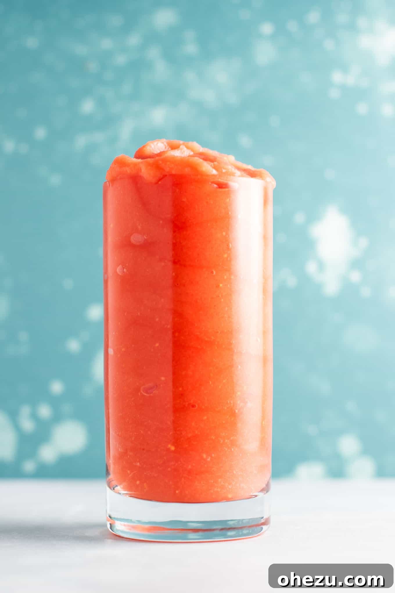 A close-up view of two tropical watermelon gin slushies in glasses, garnished with fresh mint.