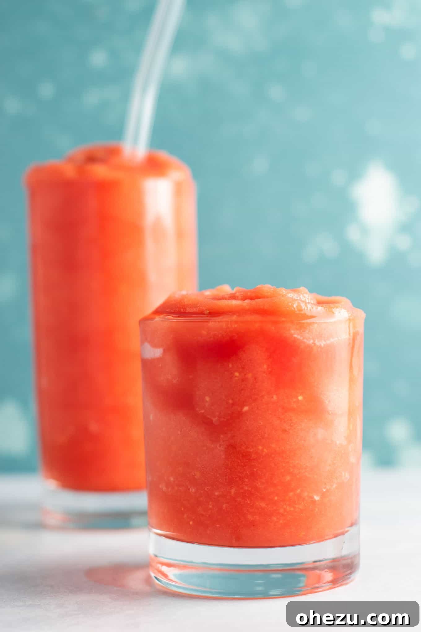 A close-up shot of a frosty watermelon gin slushie with condensation on the glass.