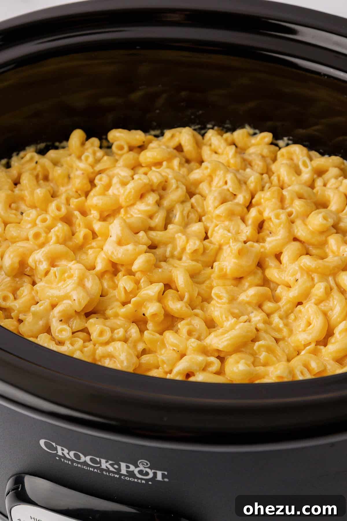 Macaroni and cheese cooking in a crock pot, illustrating the perfect creamy texture.