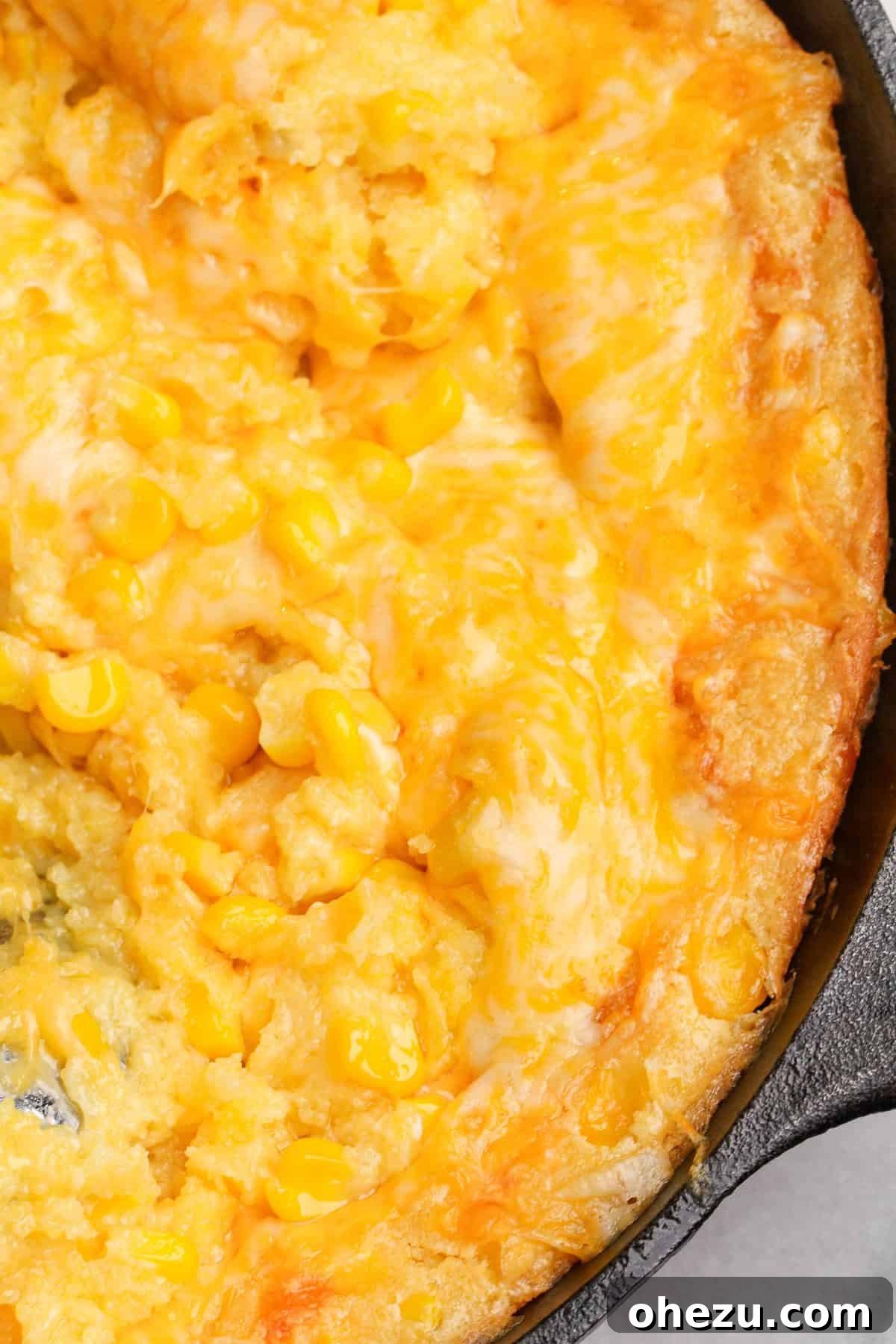 Golden Cheesy Corn Bake 3 Jiffy Corn Casserole with a spoon scooping out a portion.