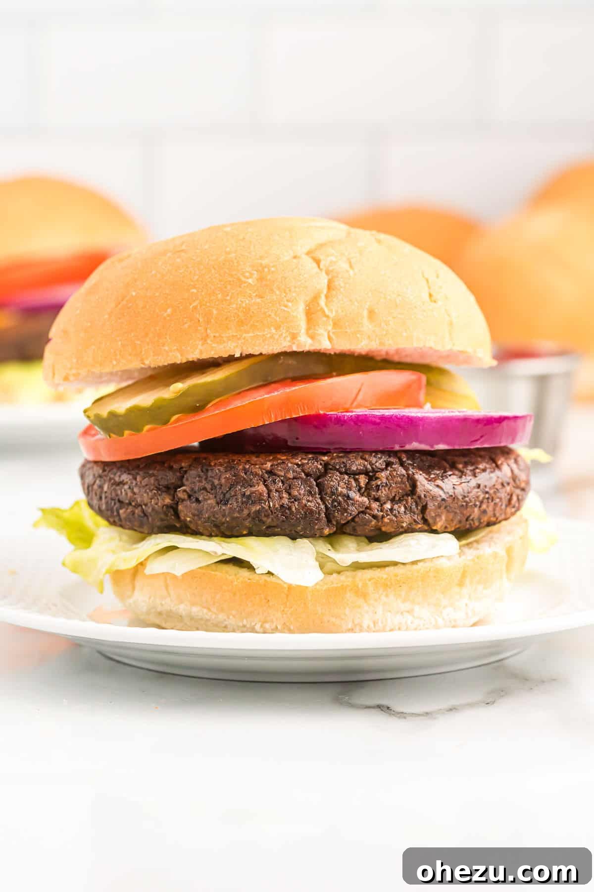 Another mouth-watering view of a black bean burger, fully dressed and ready to eat, highlighting its fresh toppings.