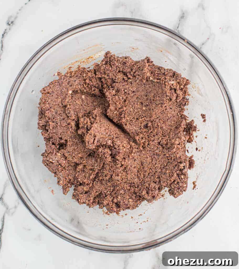 Well-mixed black bean burger batter in a mixing bowl, ready for shaping.