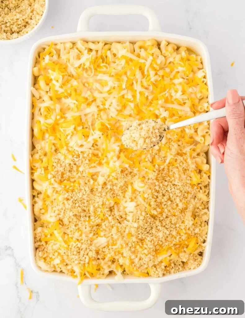 adding the bread crumb topping to the mac and cheese