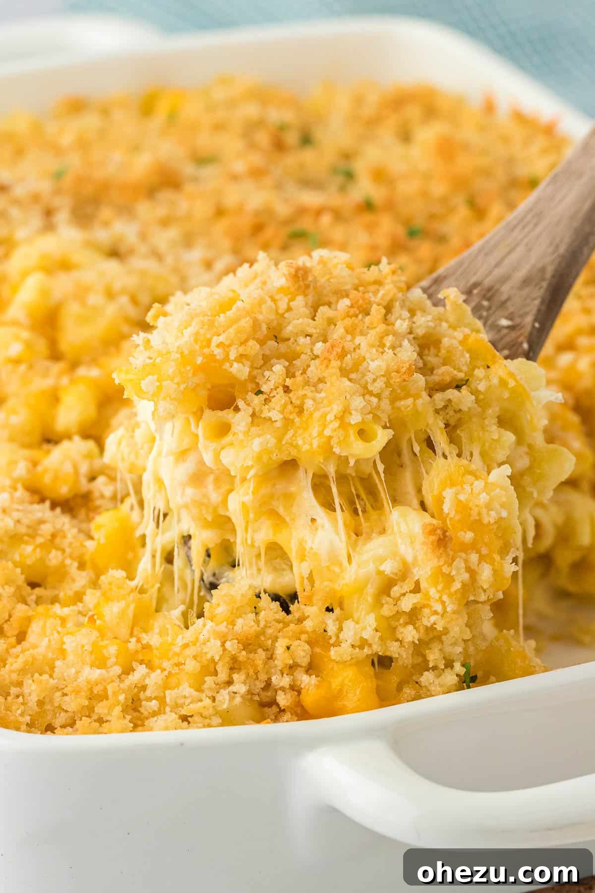 scooping mac and cheese from the baking dish