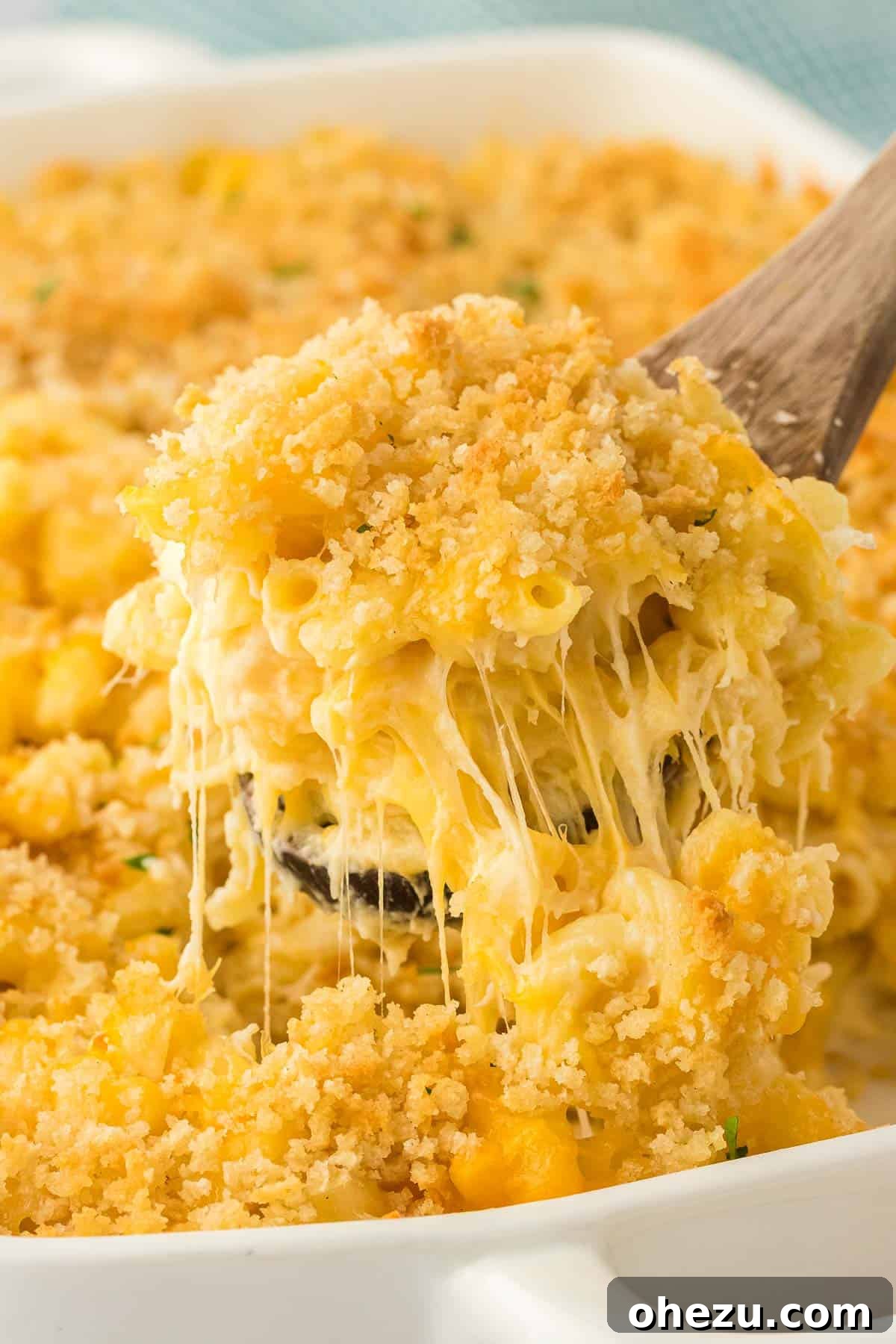 scooping mac and cheese from the baking dish