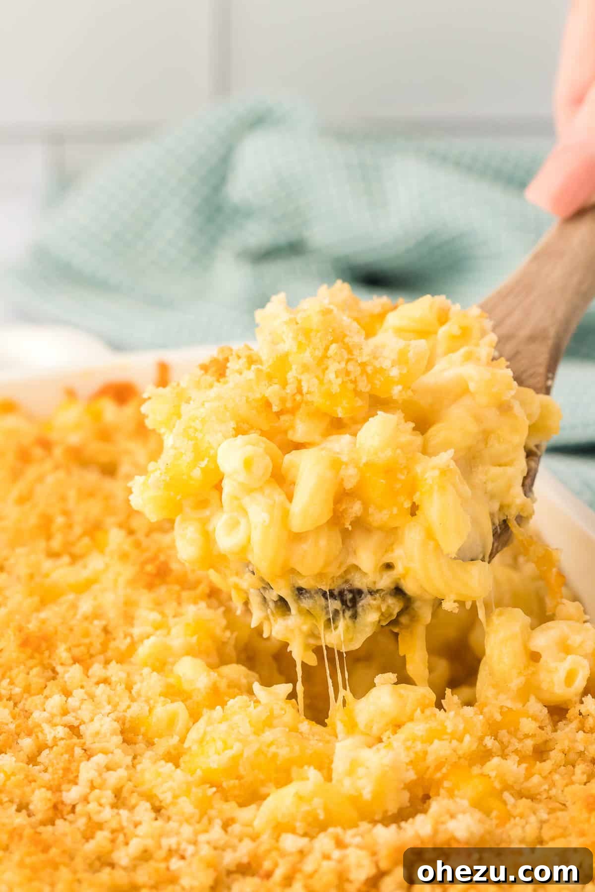 scooping mac and cheese from the baking dish